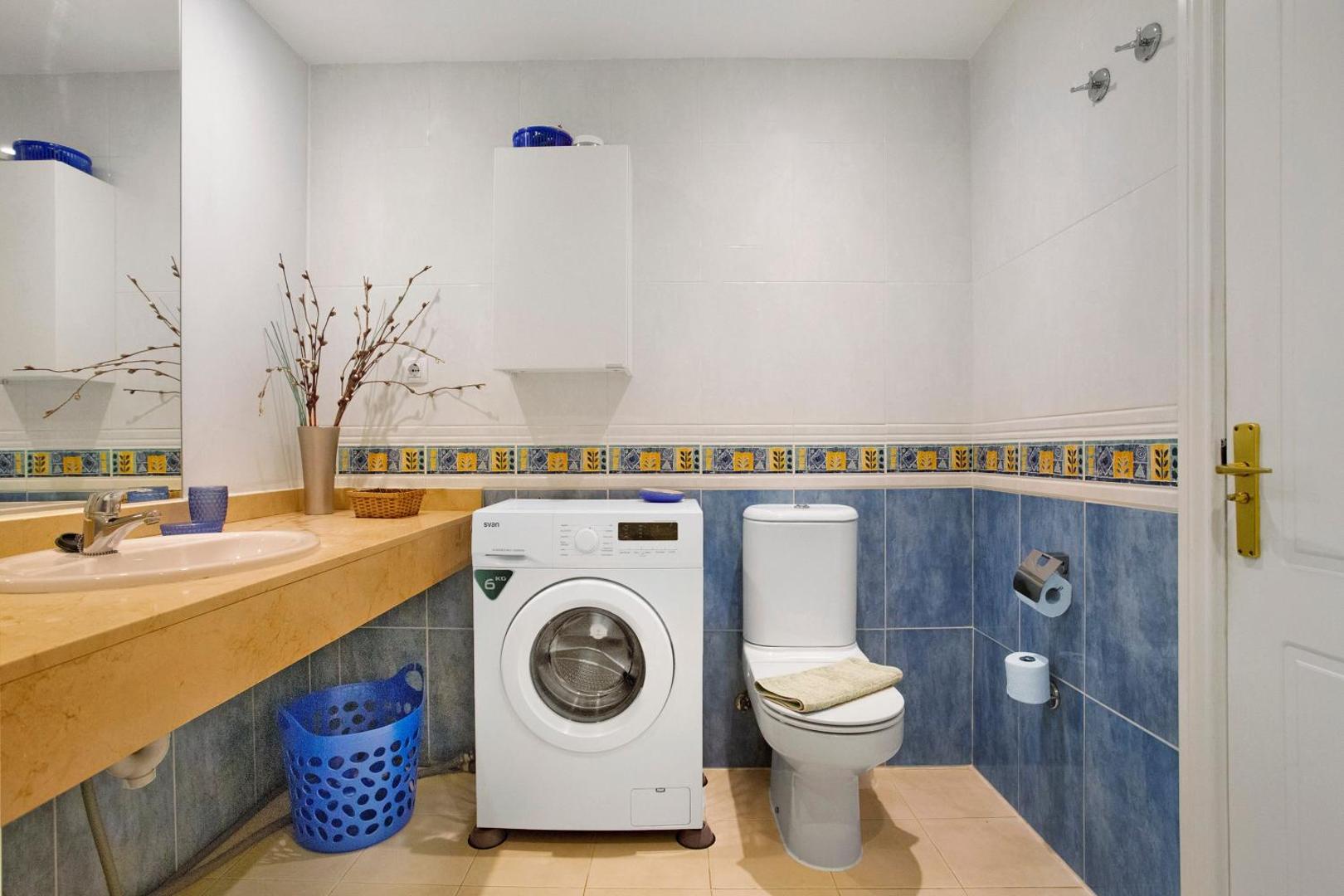Bathroom with washing machine and toilet