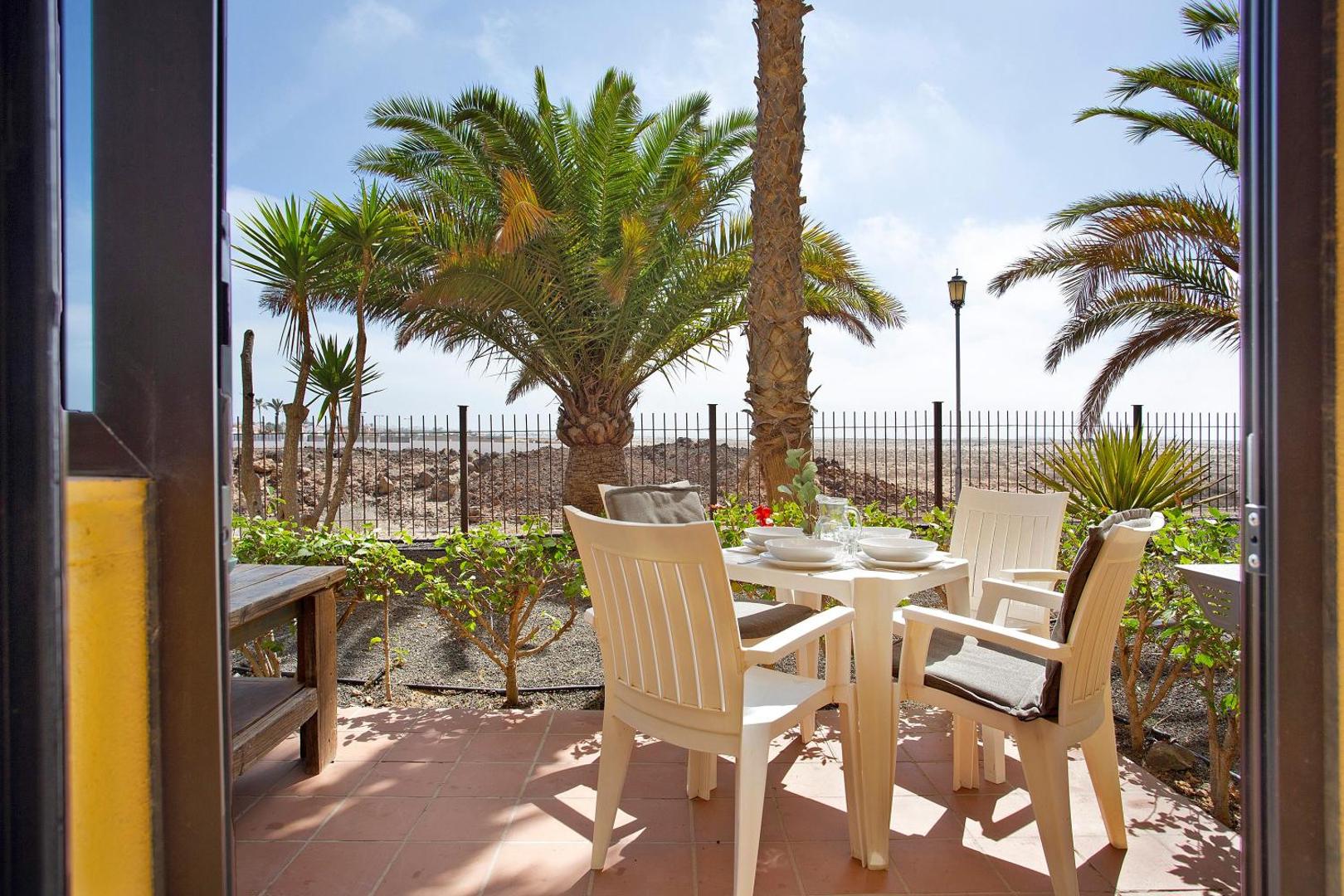 Terrace table and chairs looking out towards the sea and the dunes